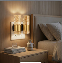 Two LED night lights plugged into a bedroom outlet next to the nightstand